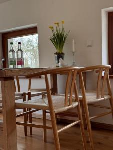 a wooden dining room table with chairs and a window at Ferienhof Vielstedt in Schürenbusch
