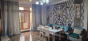a dining room with a table and a table and chairs at Corps Rose Velley in Almaty