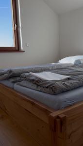 a bed with a wooden frame and a window at Ferienhof Vielstedt in Schürenbusch