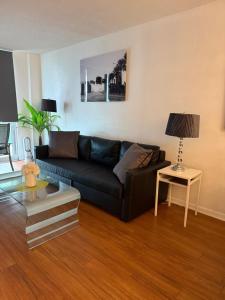 a living room with a black couch and a table at Apartments TVG Miami by the ocean ! in Miami Beach