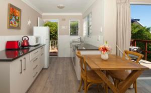 a kitchen and dining room with a table and a refrigerator at Restio Garden Studio in Simonʼs Town