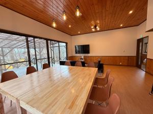 a conference room with a large wooden table and chairs at BBQ屋根付き大型ウッドデッキ川のせせらぎを聴きながら贅沢時間ペット同伴OK森と音に癒されるコテージ Rill in Nasu