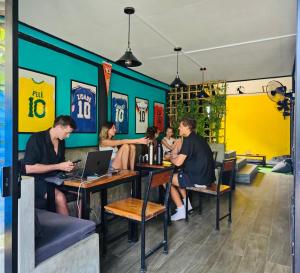 a group of people sitting at tables in a restaurant at The 10 Club Hostel & Tiny Villas in Thong Sala