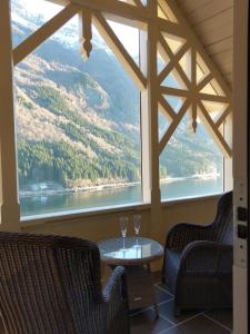 a dining room with a view of a river and mountains at Vikinghaug in Odda
