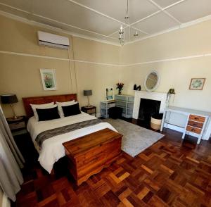 a bedroom with a large bed and a fireplace at Boer & Brit, Graaff-Reinet in Graaff-Reinet
