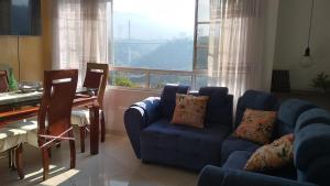 a living room with a blue couch and a window at Apartamento con vista a la ciudad en barrio campo hermoso 301 in Bucaramanga