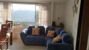 a living room with a blue couch and a window at Apartamento con vista a la ciudad en barrio campo hermoso 301 in Bucaramanga