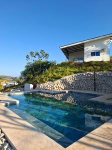 a swimming pool in front of a house at Pura Vista Lodge in Sámara