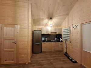 a kitchen with a stainless steel refrigerator and wooden walls at Chata Zbója - Sidzina in Sidzina