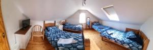 a room with three beds and a television in it at Church View B&B in Ballycastle
