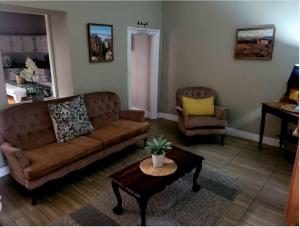 a living room with a couch and a table at Boer & Brit, Graaff-Reinet in Graaff-Reinet