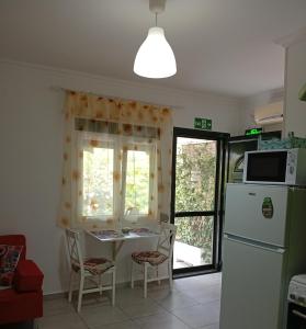 a kitchen with a table and a refrigerator at Maria's House Kontokali in Kontokali +31 photos