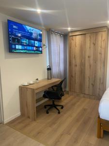 a bedroom with a desk and a television on a wall at Condor Palace in Huayllay