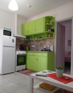 a kitchen with green cabinets and a white refrigerator at Maria's House Kontokali in Kontokali