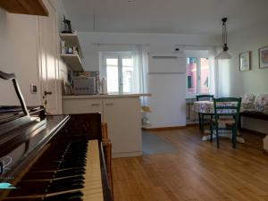 a kitchen and living room with a piano in a room at Ochin de Ma' a Boccadasse - Genovainrelax in Genoa