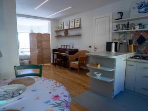 a kitchen and dining room with a table and a kitchen with a stove at Ochin de Ma' a Boccadasse - Genovainrelax in Genoa +10 photos