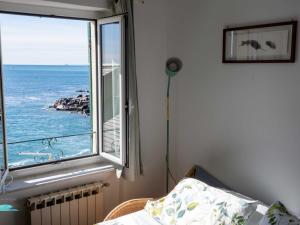 a bedroom with a window with a view of the ocean at Ochin de Ma' a Boccadasse - Genovainrelax in Genoa