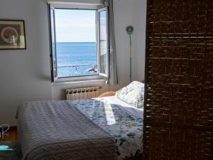 a bedroom with a bed and a view of the ocean at Ochin de Ma' a Boccadasse - Genovainrelax in Genoa