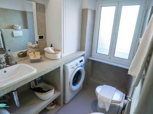a bathroom with a washing machine and a sink at Ochin de Ma' a Boccadasse - Genovainrelax in Genoa