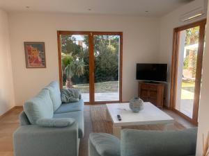 a living room with two blue chairs and a table at Vivez Cala Morell! in Cala Morell