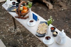a table with food and drinks and a basket of fruit at The Bagh Kufri - A Himalayan Retreat in Kūfrī