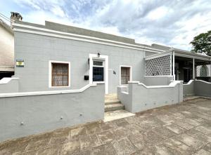 a white building with a porch and a courtyard at Boer & Brit, Graaff-Reinet in Graaff-Reinet