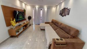 a living room with a couch and a tv at Recanto da Saudade, 3 Quartos, Piscina, Churrasqueira in Boituva