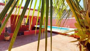 a palm tree in front of a house with a swimming pool at Recanto da Saudade, 3 Quartos, Piscina, Churrasqueira in Boituva