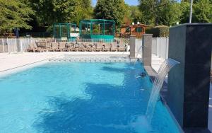 a swimming pool with a water fountain and a gazebo at Mobile home Besse in Besse-et-Saint-Anastaise
