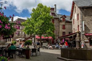 a group of people sitting at tables in a street at Mobile home Besse in Besse-et-Saint-Anastaise