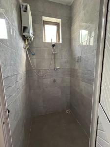 a bathroom with a shower with a window and a shower at The cozy nest in Curepipe +14 photos