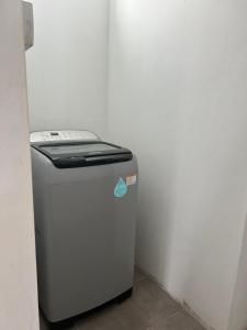 a small white refrigerator in a corner of a room at The cozy nest in Curepipe