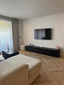 ein Wohnzimmer mit Sofa und Flachbildfernseher in der Unterkunft Boulevard 3E in Arnhem
