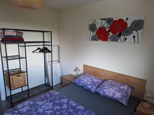 ein Schlafzimmer mit einem Bett und einem Blumenbild an der Wand in der Unterkunft Studio Keppelborn in Sankt Vith