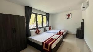 a bedroom with two beds and a window at Luxury Hotel in Tây Ninh