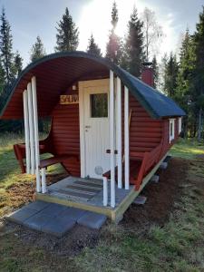 a small red cabin with a pitched roof at Mökki Katjukka, Ruka in Kuusamo