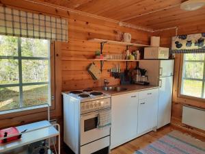 a kitchen with a stove and a refrigerator at Mökki Katjukka, Ruka in Kuusamo