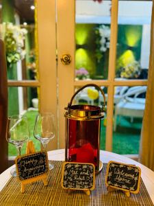a tea pot on a table with two glasses at Victorian Elegance Luxury Stays in Amritsar