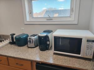a kitchen counter with a microwave and appliances on it at Bright Ensuite Room with 2 Queen Beds-3A in Halifax