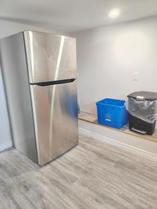 a stainless steel refrigerator in a kitchen with a shelf at Bright Ensuite Room with 2 Queen Beds-3A in Halifax