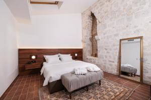 a bedroom with a large bed and a mirror at Heritage Hotel Maskovica Han in Pakoštane
