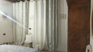 a bedroom with a bed and a window with curtains at La Libellula in Capannoli