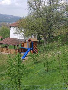 a playground in a field next to a house at Vikendica i vajat Vrbica in Kalesija