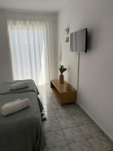 a bedroom with a bed and a television on a wall at Sea View Luxury Studios in Vrachonisída Palaiókastro