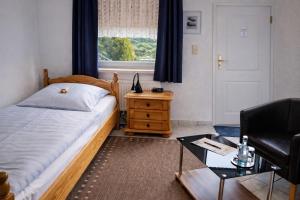 a bedroom with a bed and a chair and a table at Mecklenburger Hof in Parchim