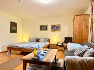 a living room with a bed and a couch at Apartment Bayerischer Wald - Ferienwohnung mit Küche, Parkplatz, WLAN & 24h Checkin in Waffenbrunn +13 photos
