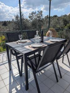 ein Tisch mit Gläsern und einer Flasche Wein auf einer Terrasse in der Unterkunft Villa Debriz Apartment in Stréfion