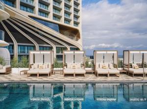 a hotel pool with lounge chairs and a building at IsLe Royal Suites By Mercury Tower in St. Julianʼs