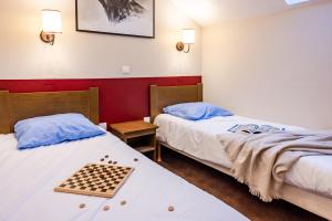 a room with two beds with a chess board on the bed at Résidence Pierre & Vacances l'Albane in Vars