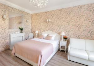 a bedroom with a large bed and a white couch at Cannes Imperial Croisette Palais Miramar in Cannes +22 photos
